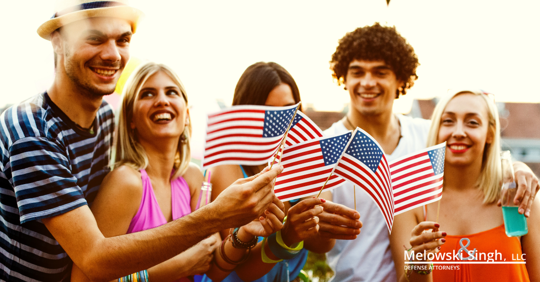young adults holding flags drinking having fun