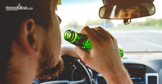 man driving dui drinking alcohol in a car