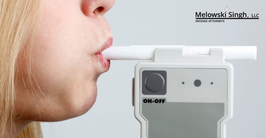 woman blowing into breathalyzer