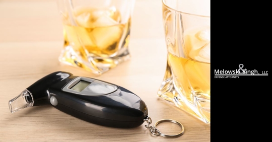 breathalyzer with two glasses of alcohol behind it