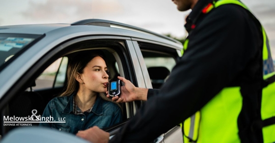 Young woman doing driver alcohol test on street