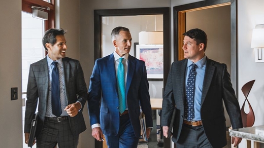 Three men in suits walking forward